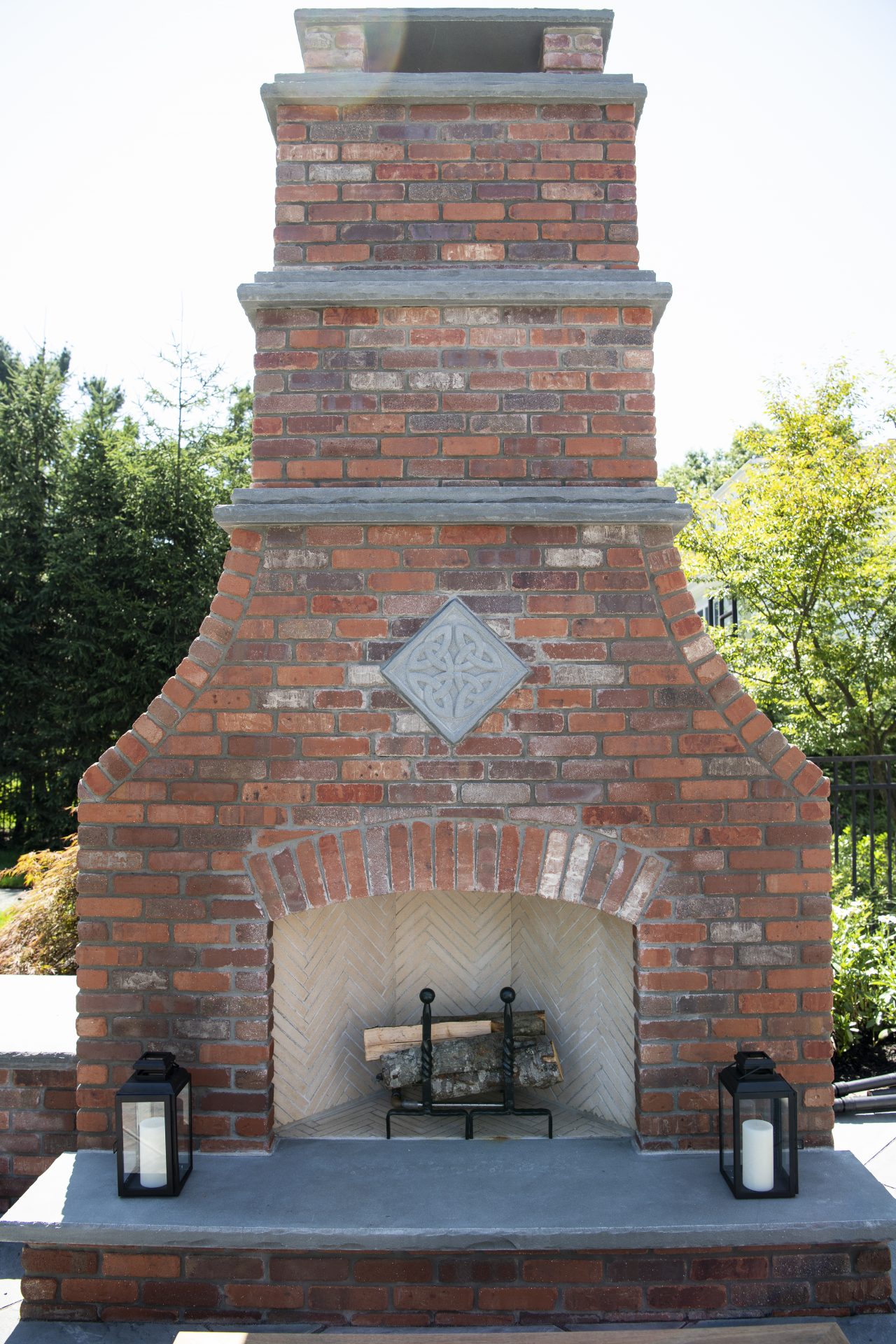 Outdoor red brick fireplace with lanterns