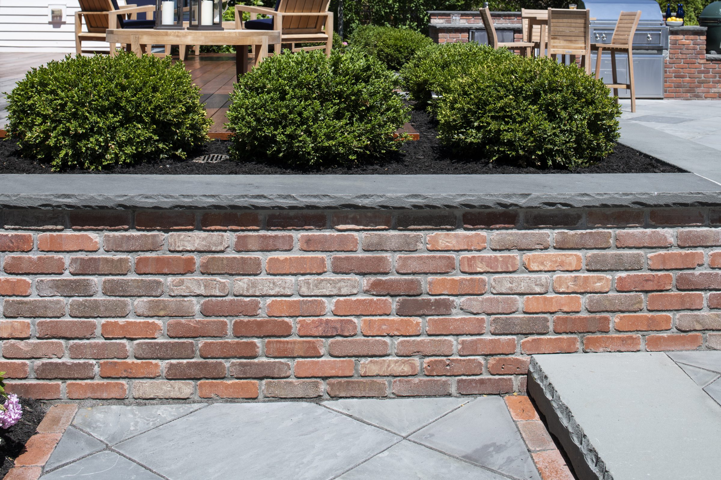 Brick patio with bushes and furniture
