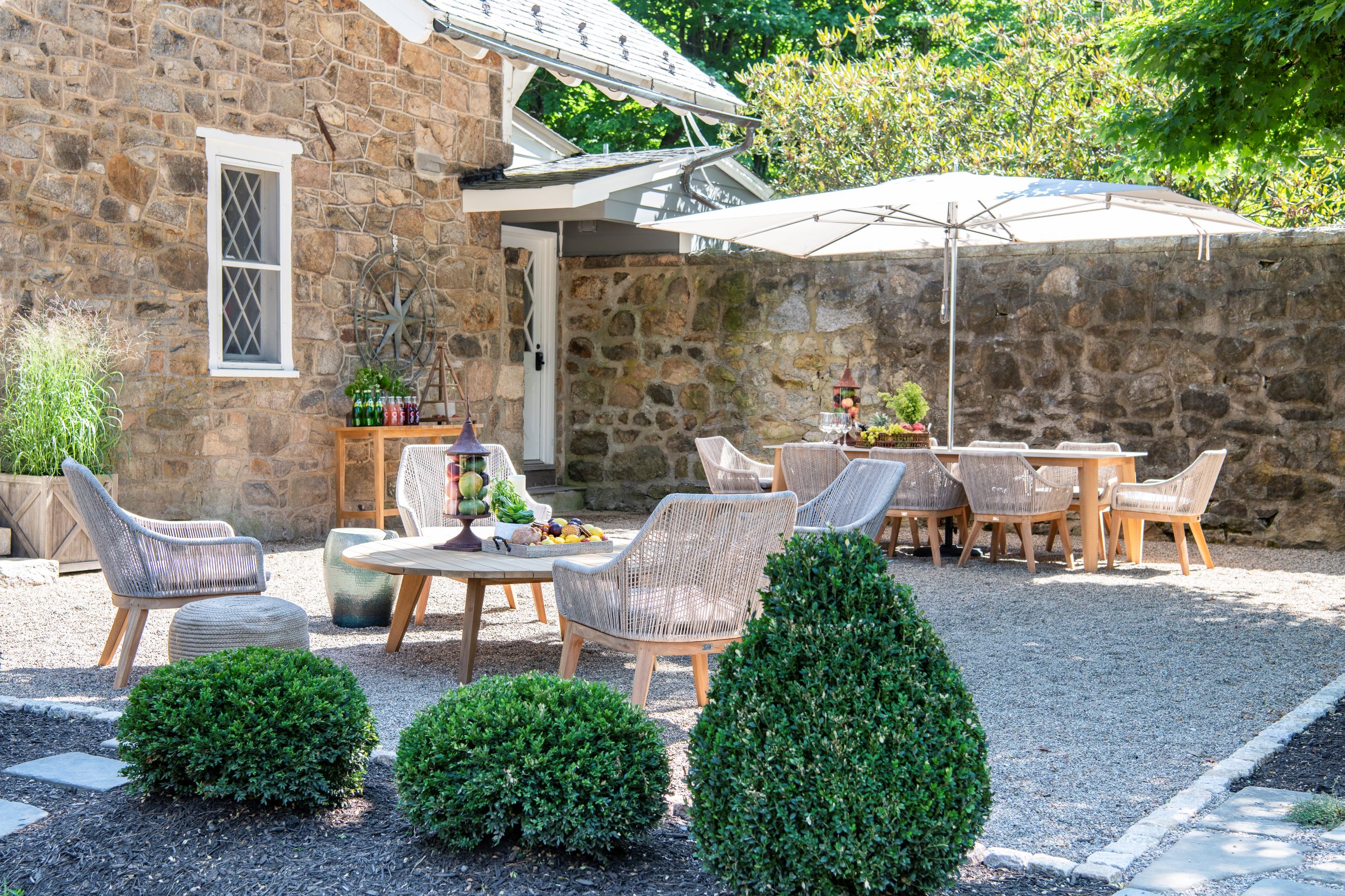 Elegant outdoor patio with furniture and greenery.