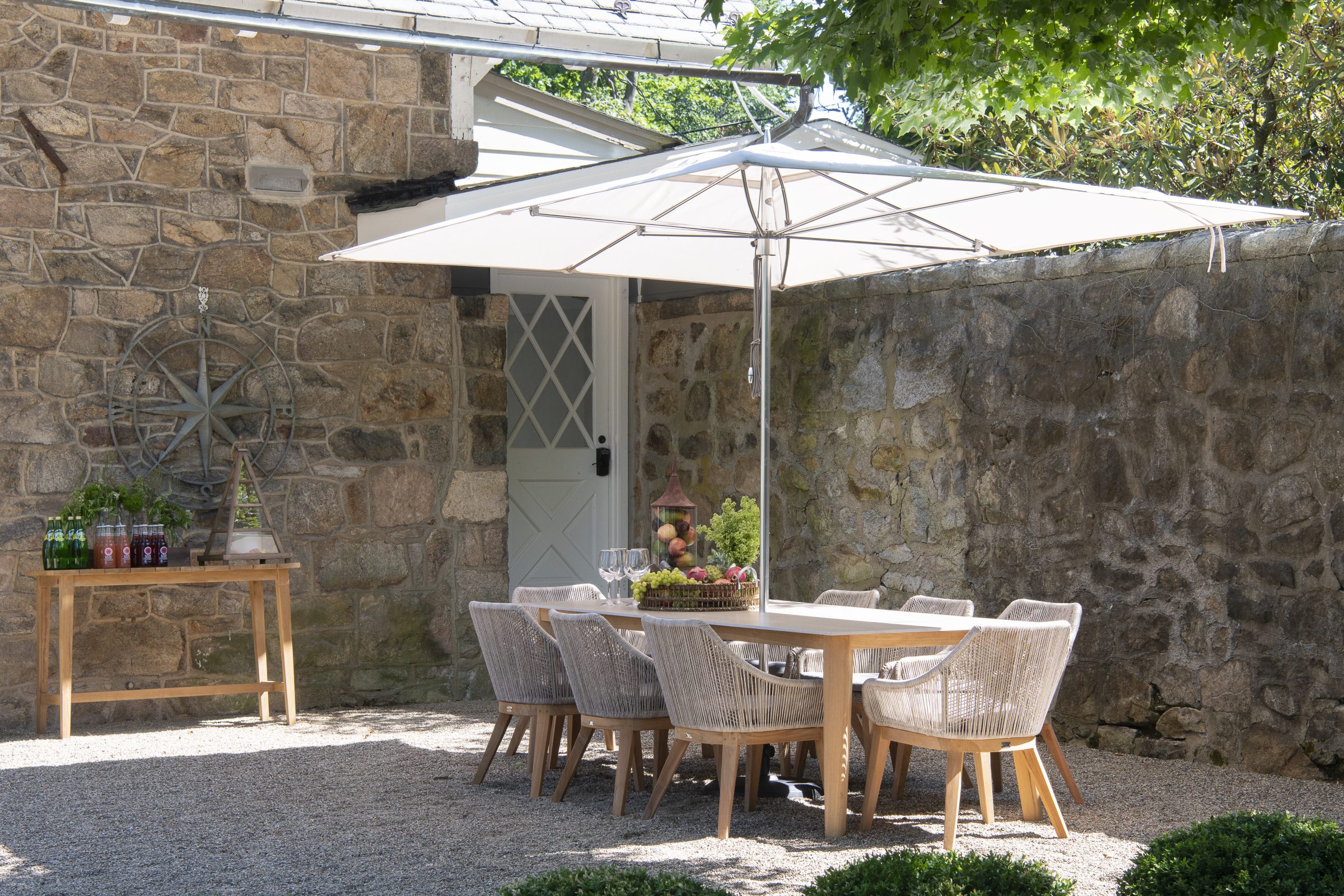 Outdoor dining area with umbrella and stone wall