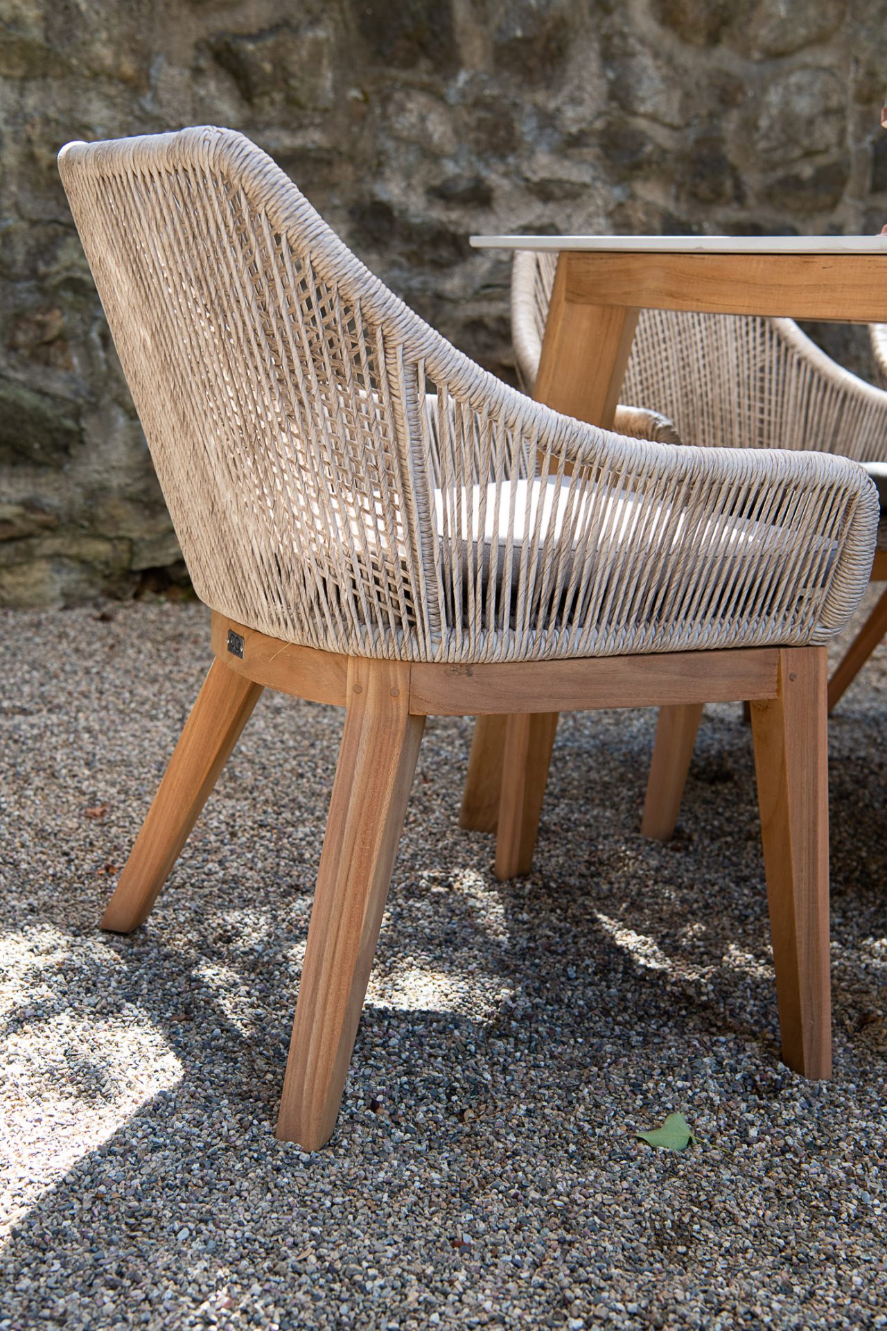 Woven outdoor chair beside wooden table