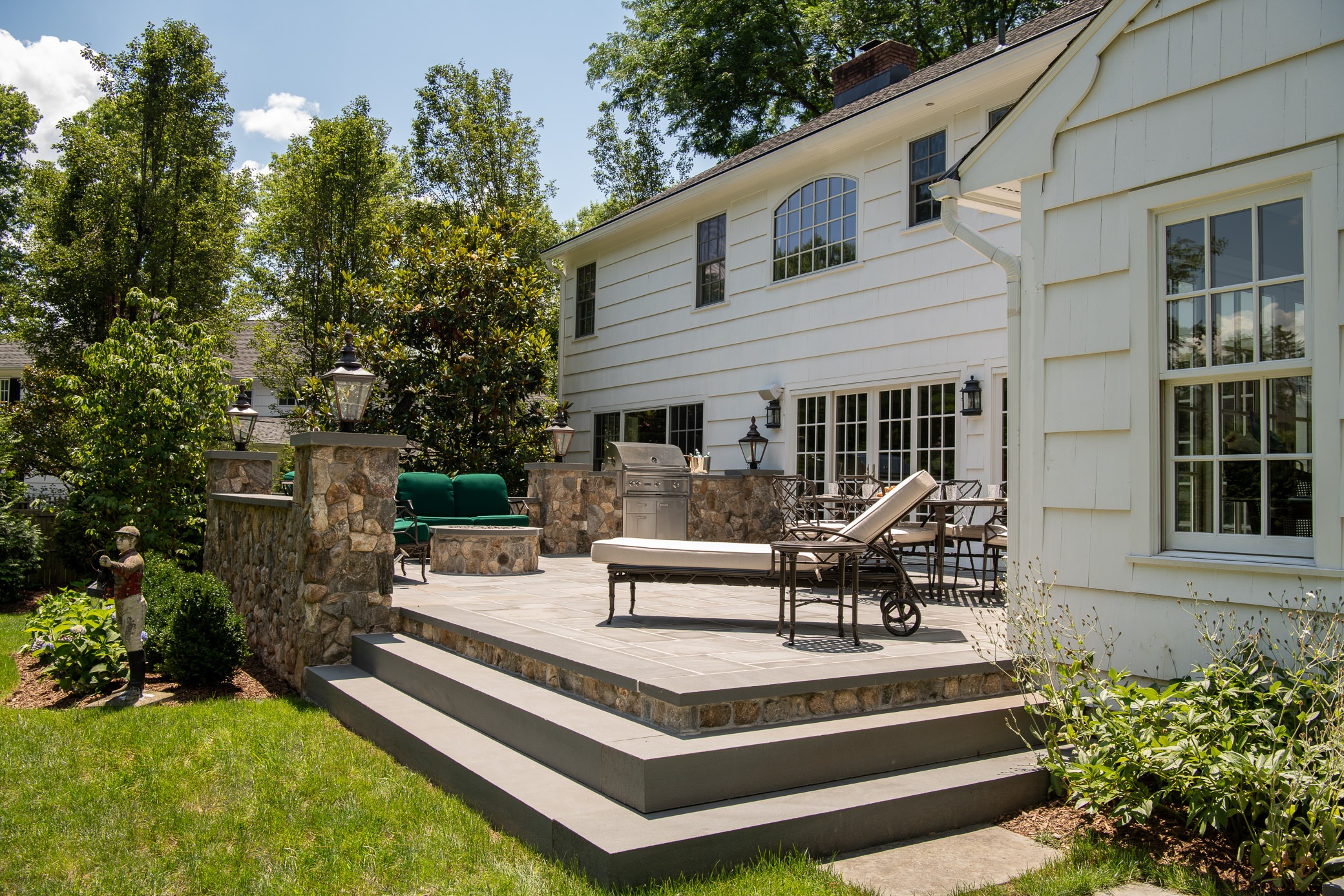 Backyard patio with furniture and grill.