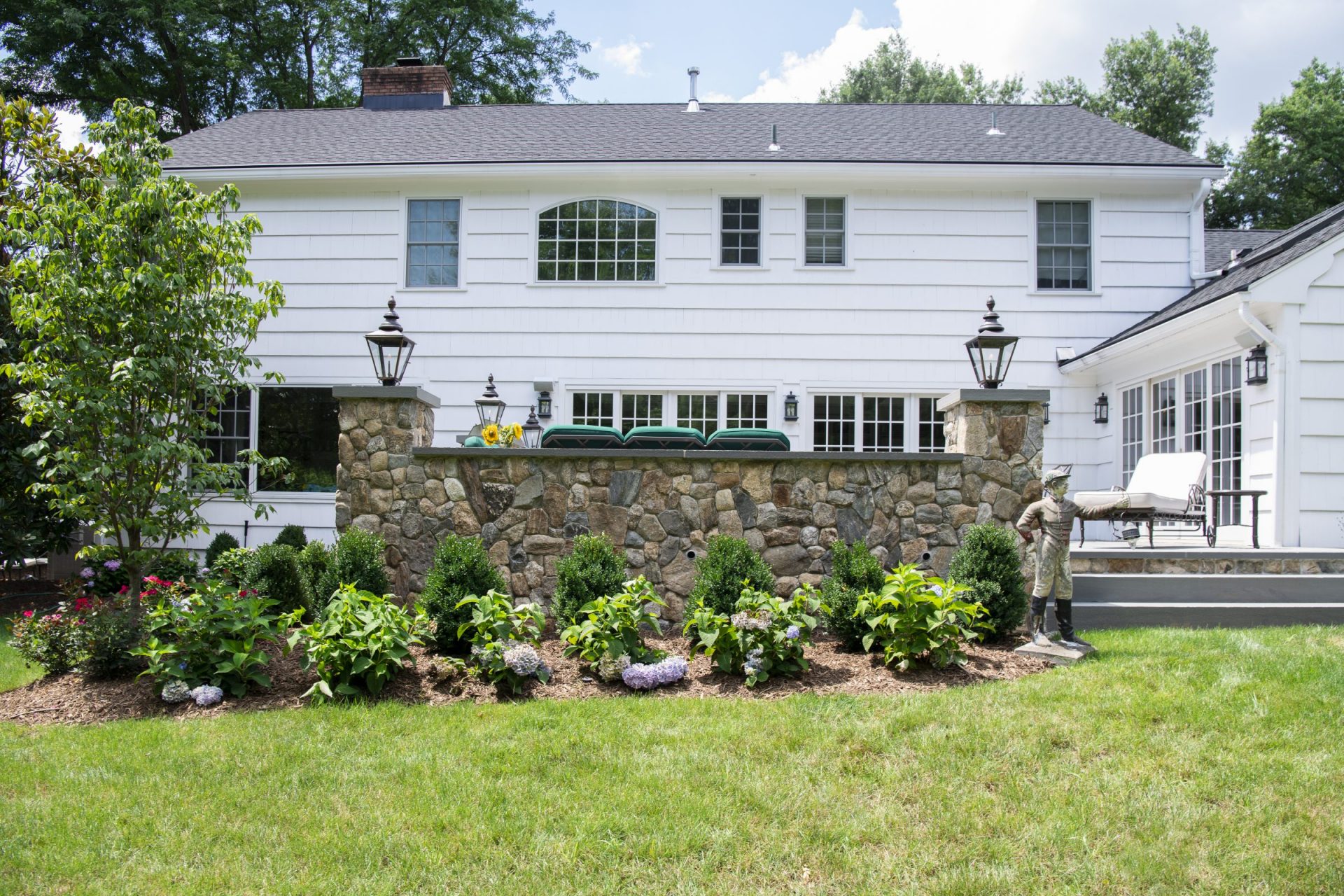 Elegant white house with stone garden wall.