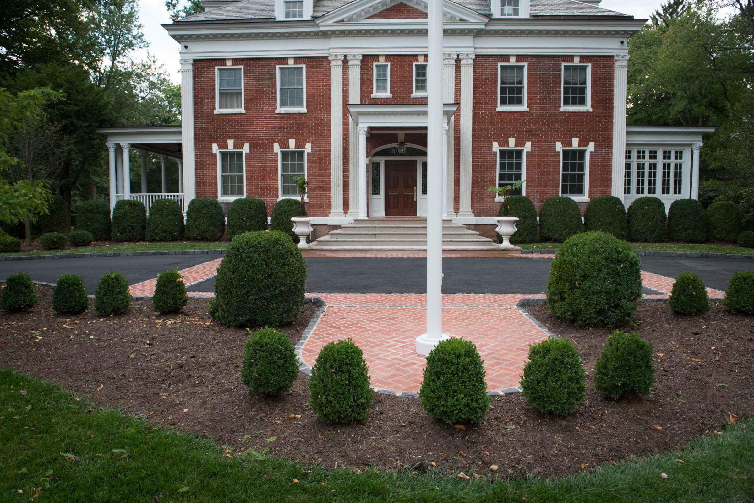 Classic red brick mansion with manicured bushes