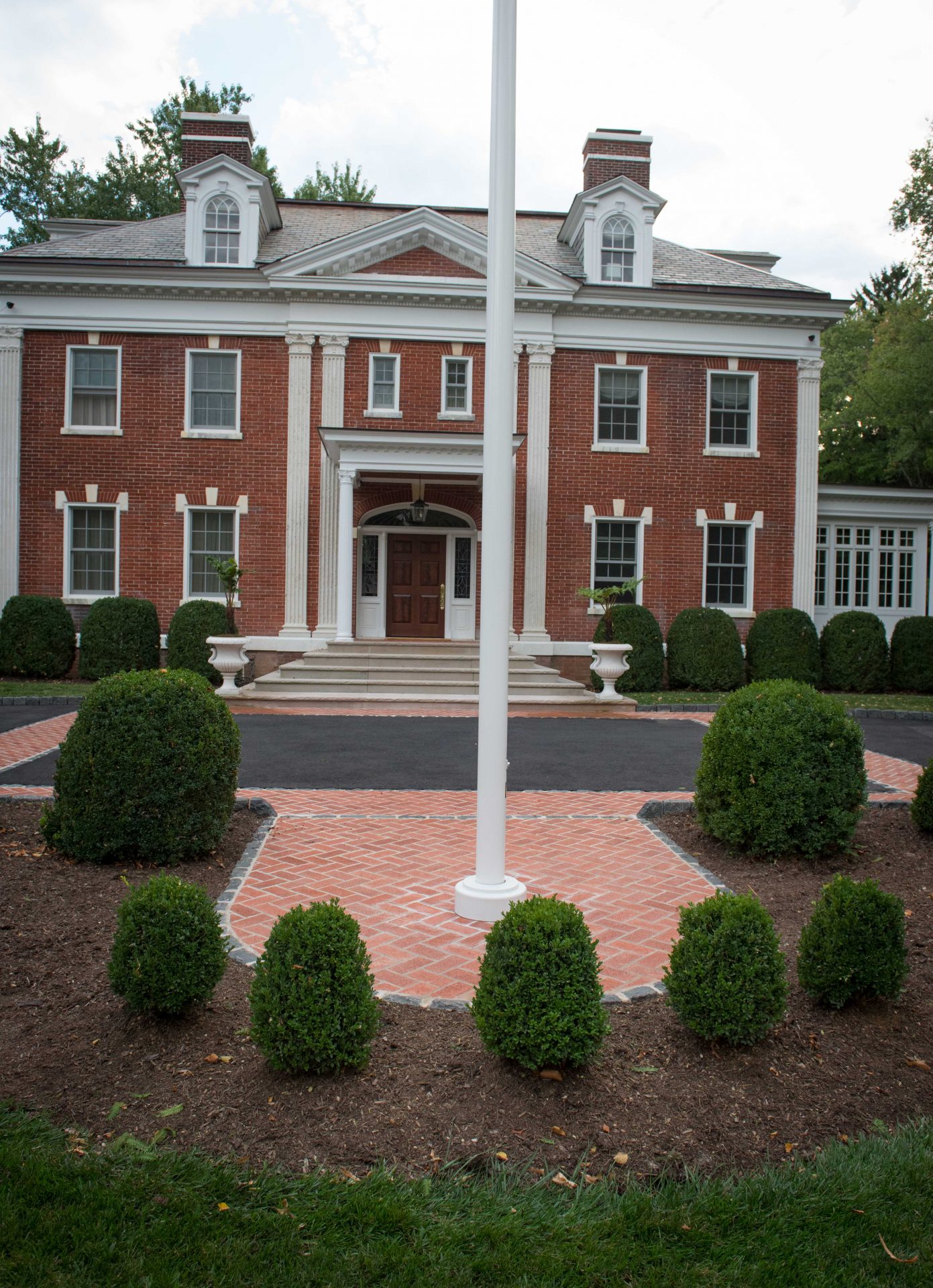 Historic red brick building with manicured bushes