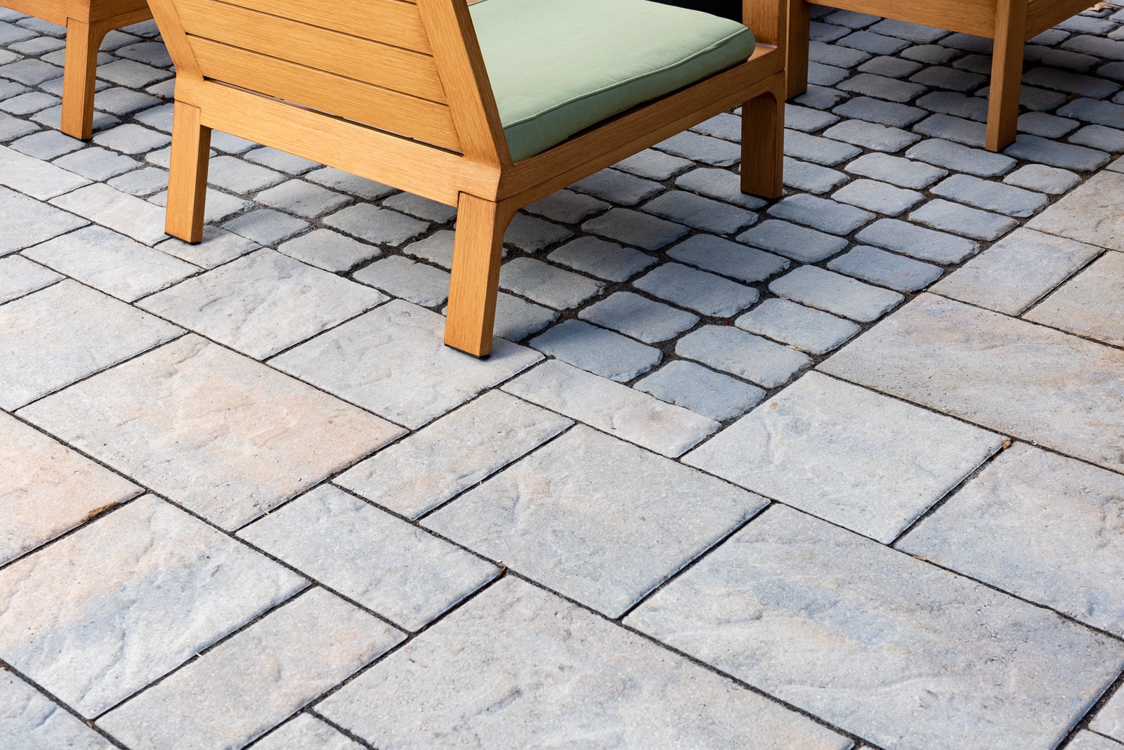 Wooden patio chairs on stone pavement
