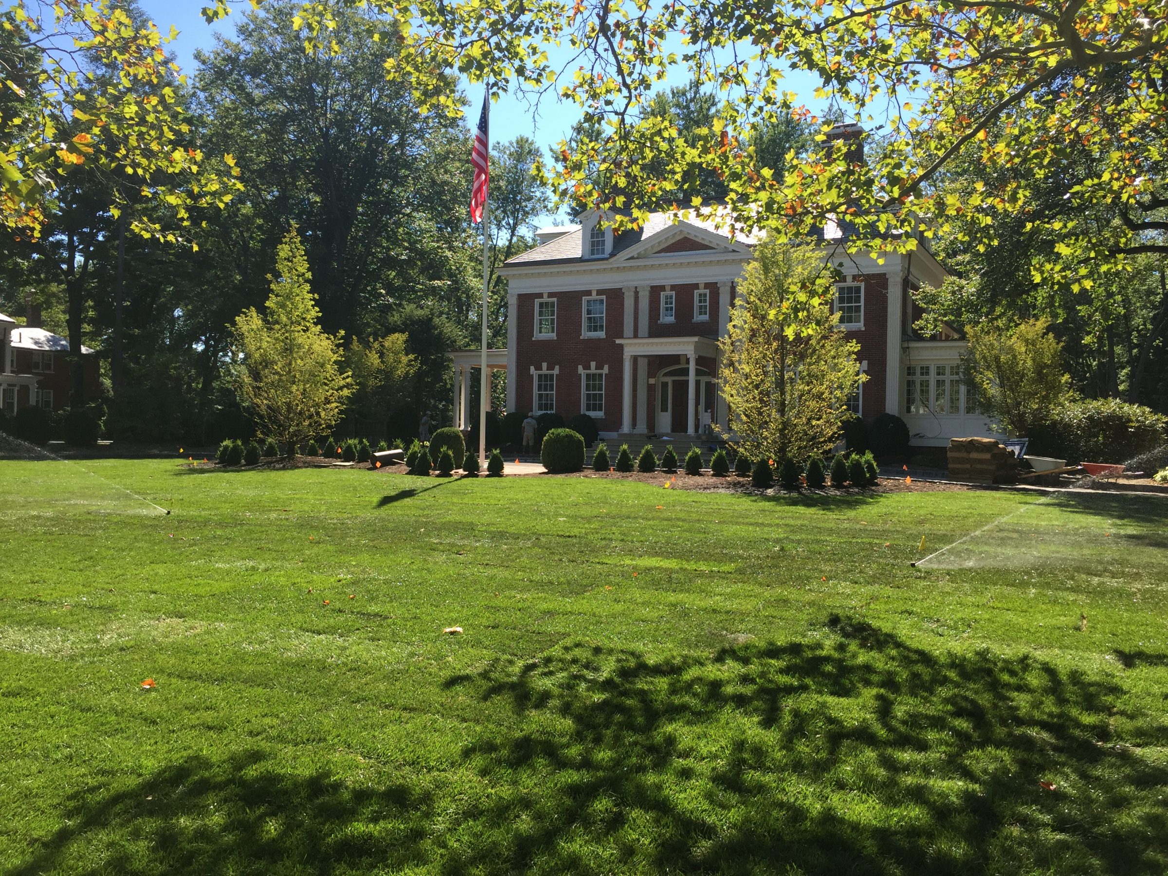 Large brick house with manicured lawn.
