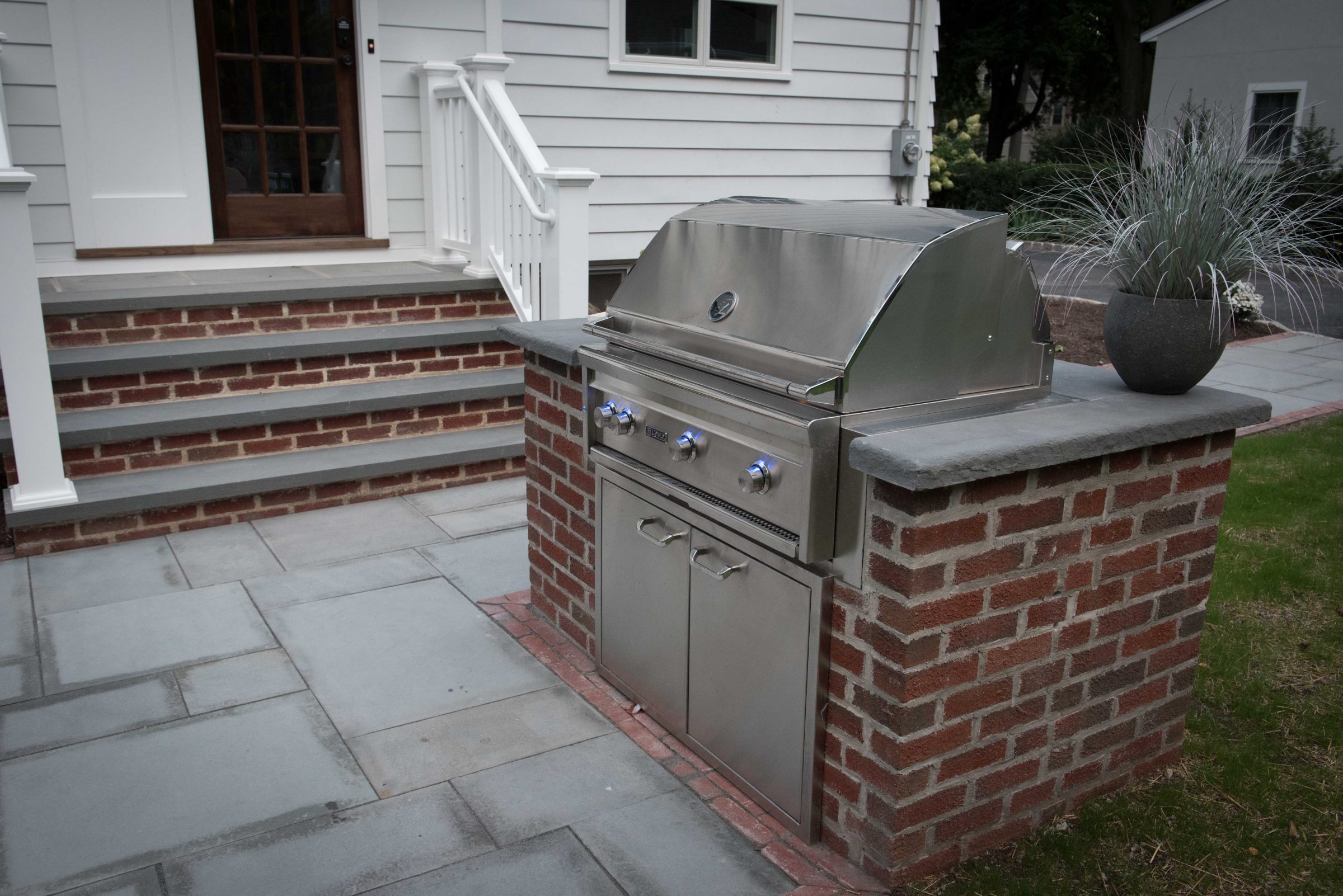 Outdoor brick barbecue with stainless steel grill.