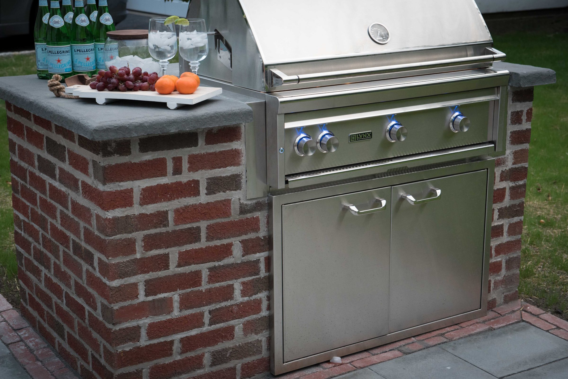Outdoor grill with refreshments and fruit.