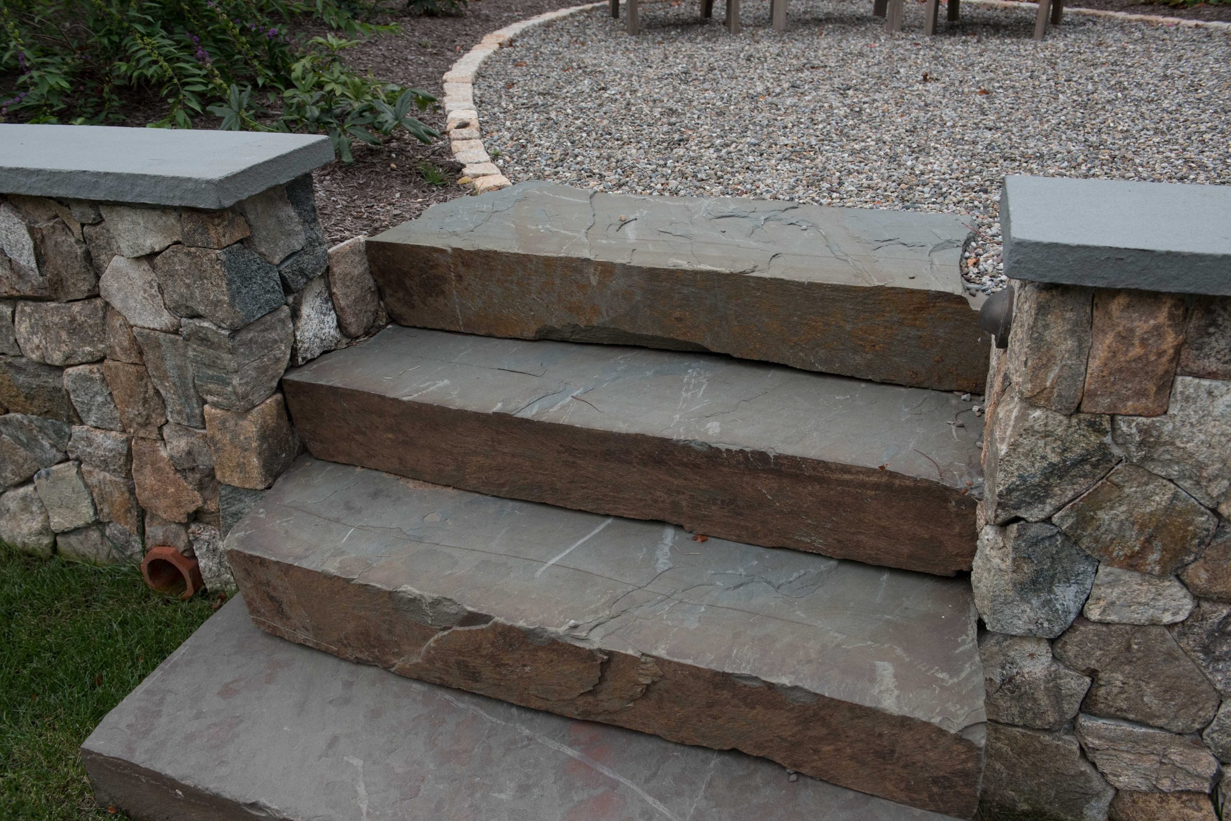 Stone steps leading to a gravel patio