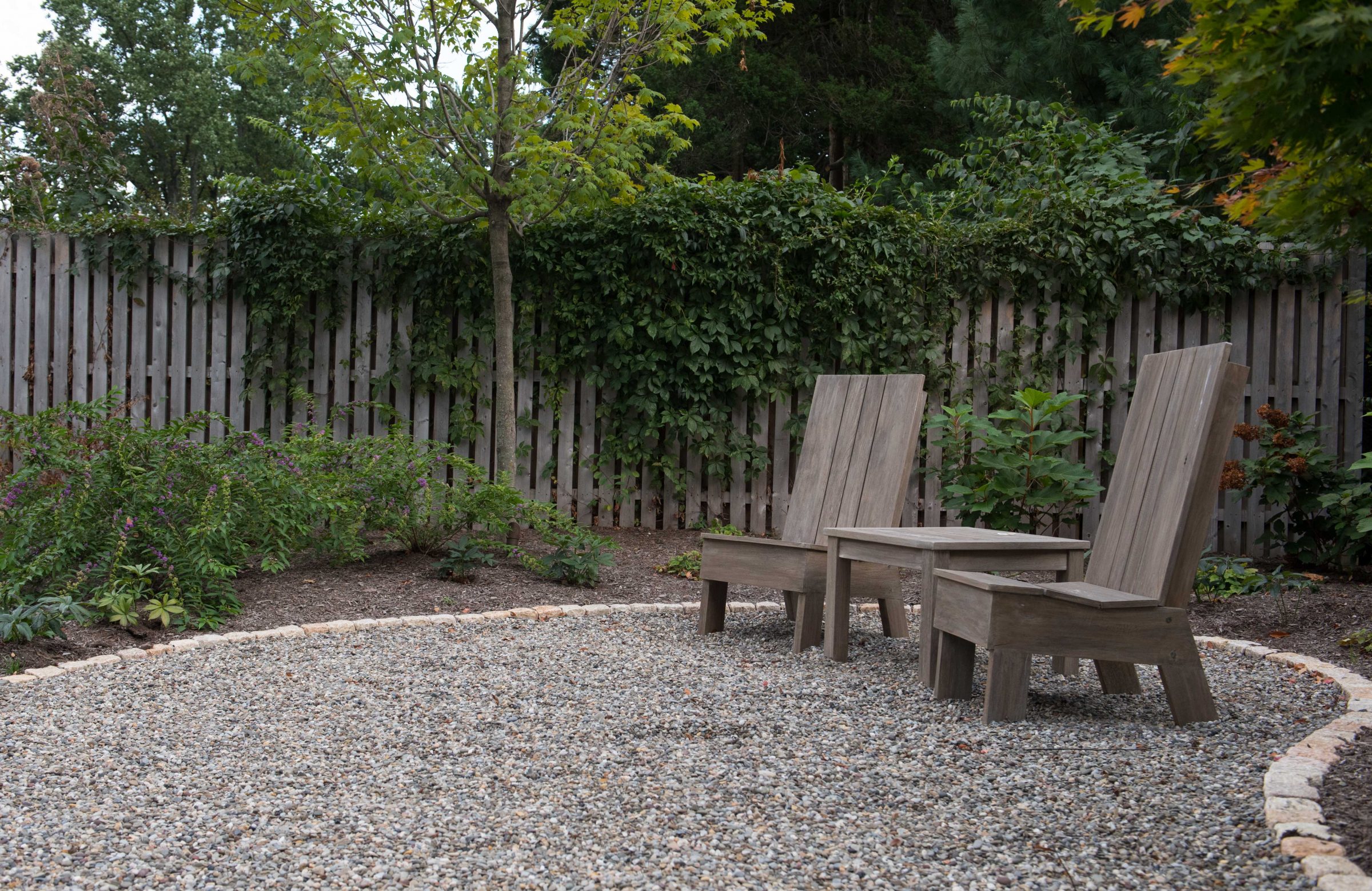 Two wooden chairs in a backyard garden