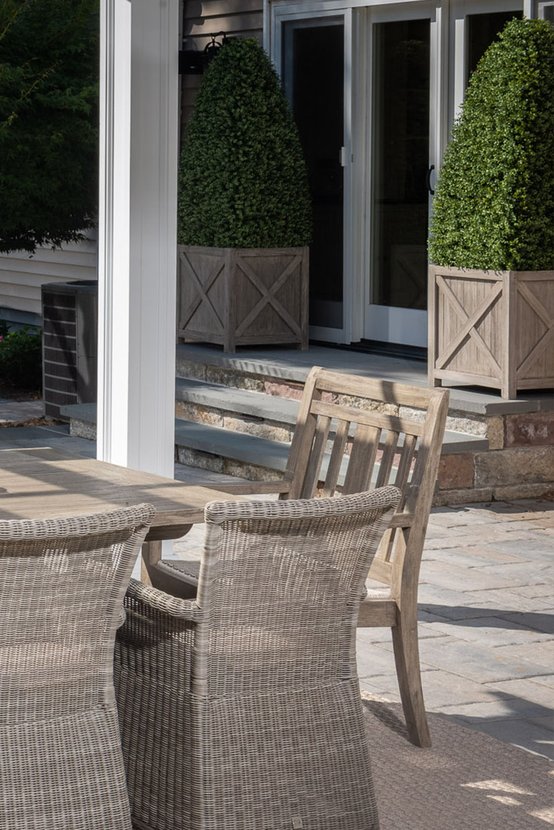 Outdoor patio with wicker furniture and topiary