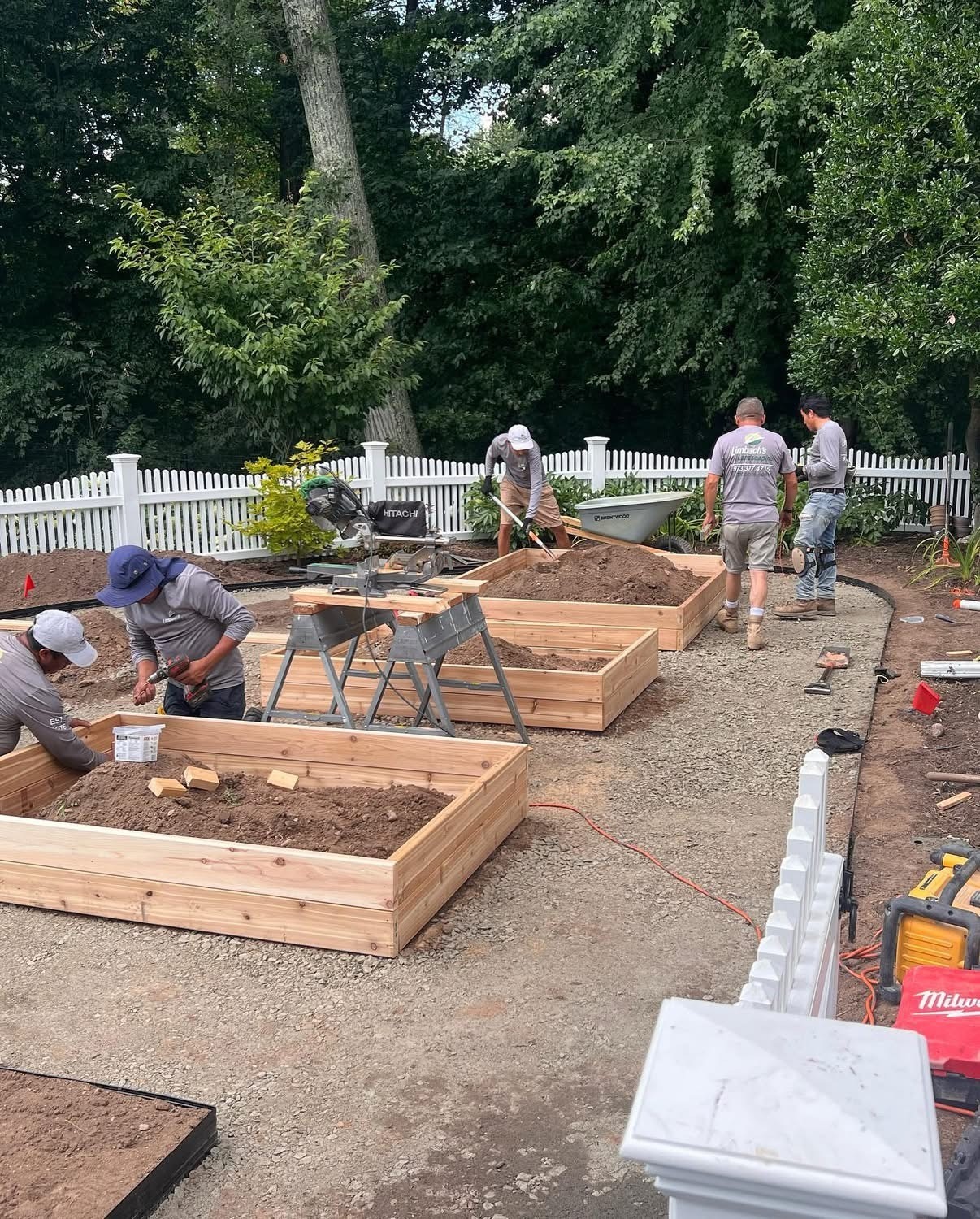Gardeners constructing raised wooden garden beds