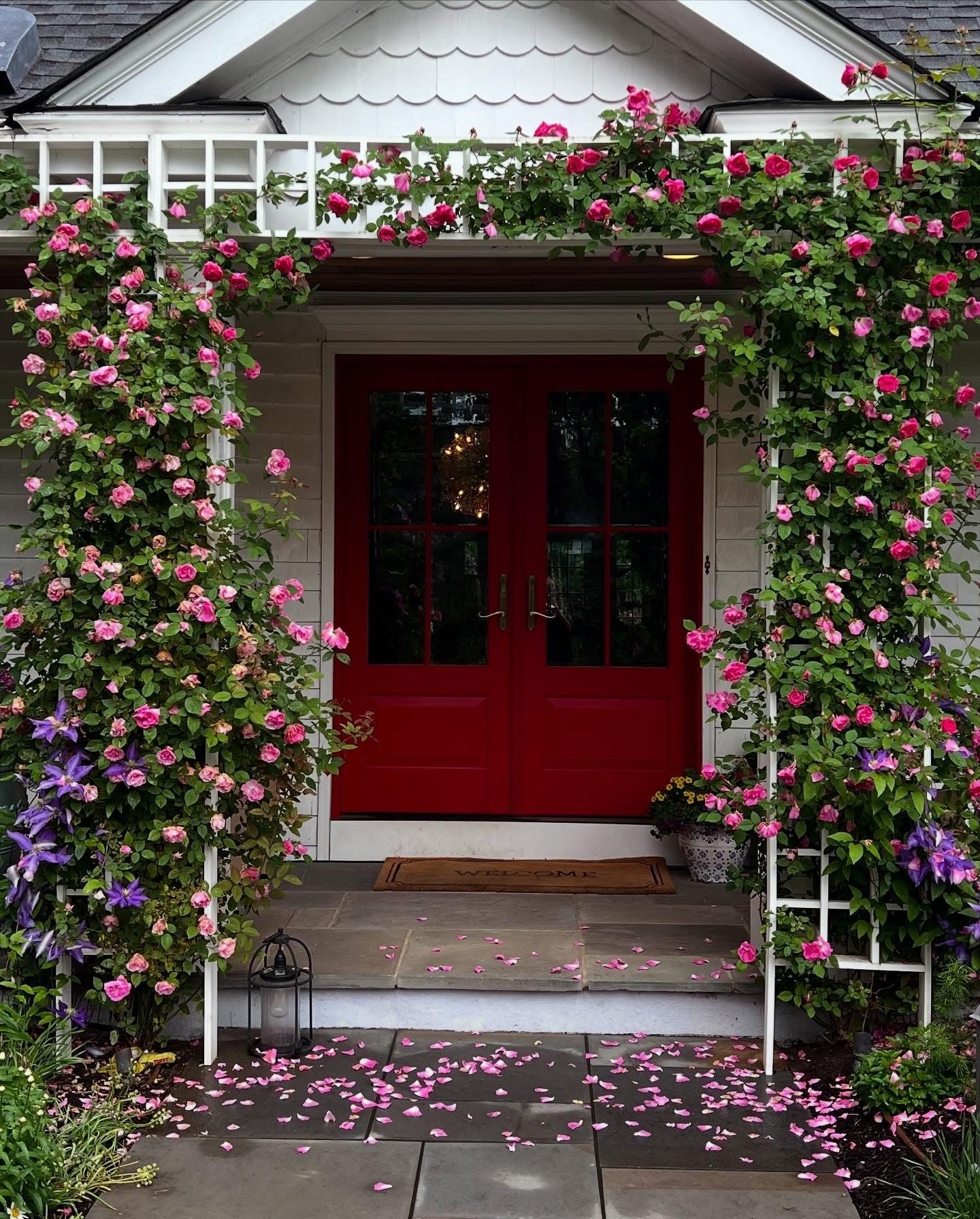 Charming porch with red doors and pink roses.