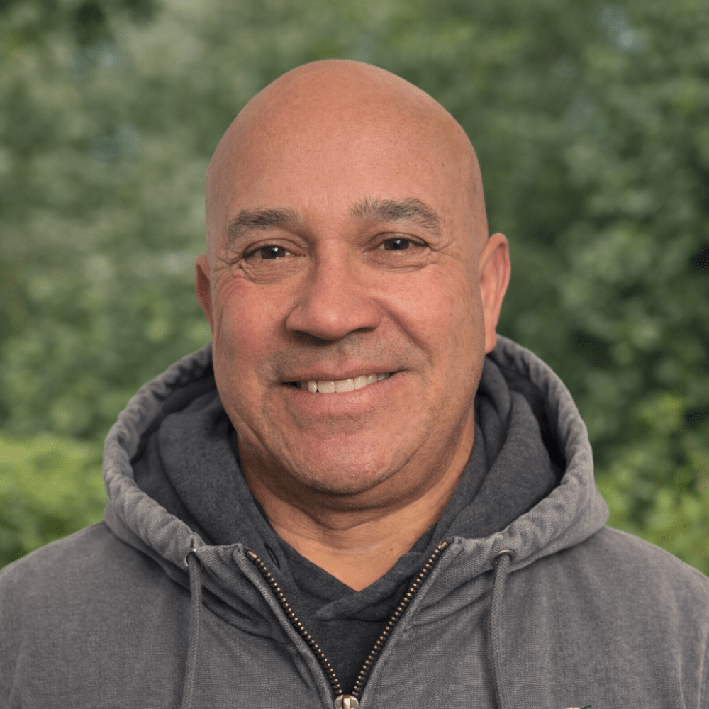 Smiling man in gray hoodie outdoors