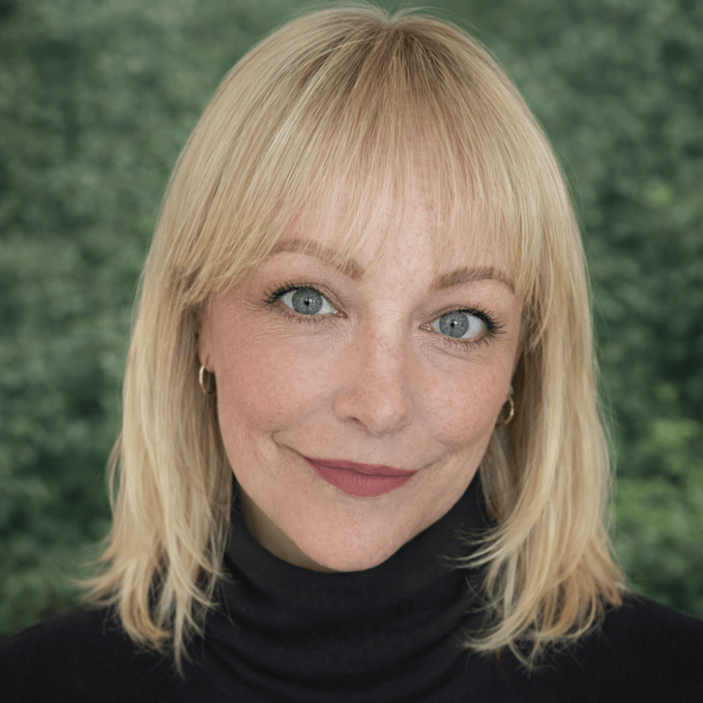 Smiling woman with blonde hair and green background