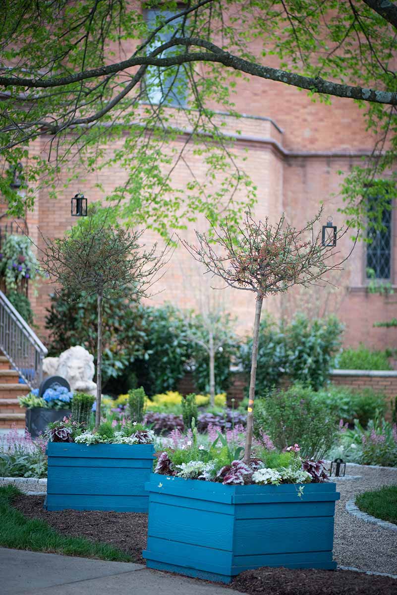 Garden with blue planters and brick building.