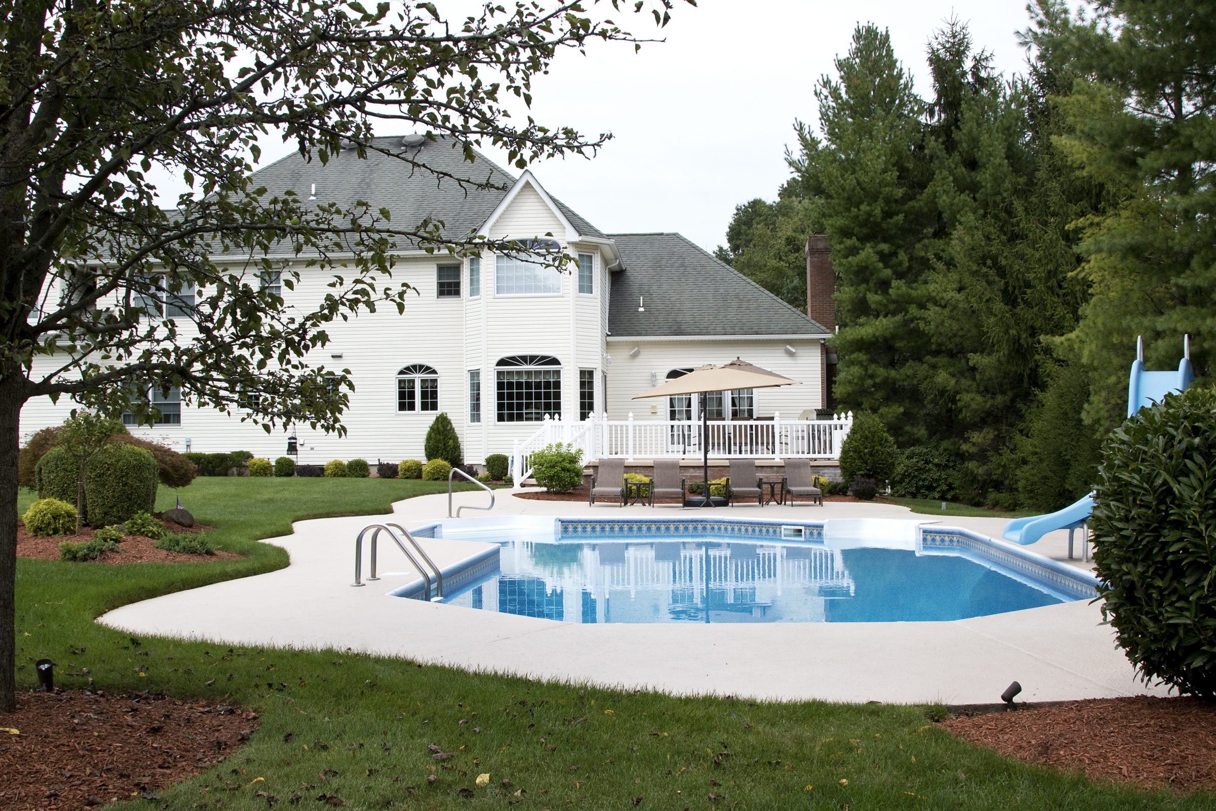 Backyard pool with patio and slide