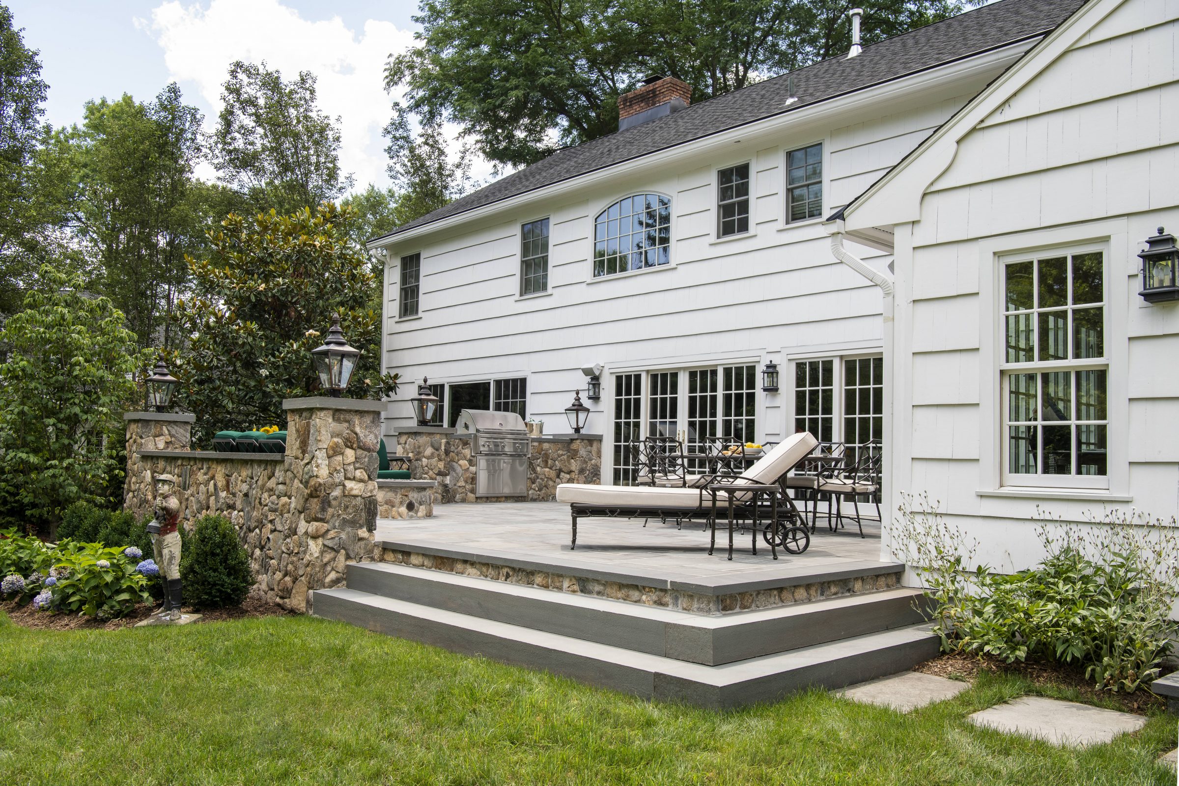 Custom hardscape patio design featuring an outdoor kitchen and dining area in Northern New Jersey.